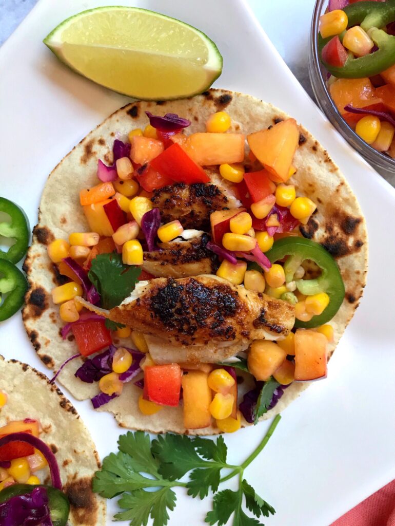 Overhead shot of fish tacos with corn & nectarine salsa