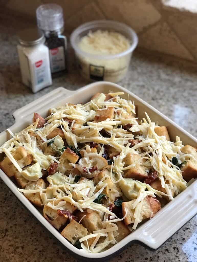 Overhead shot of unbaked, prepared Sun-dried Tomato & Artichoke Strata