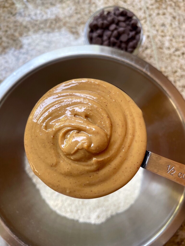 Overhead view of a measuring cup full of creamy peanut butter