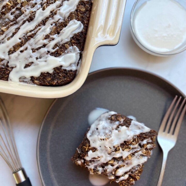 Overhead shot of a slice of Gingerbread Baked Oatmeal next to a pan of oatmeal