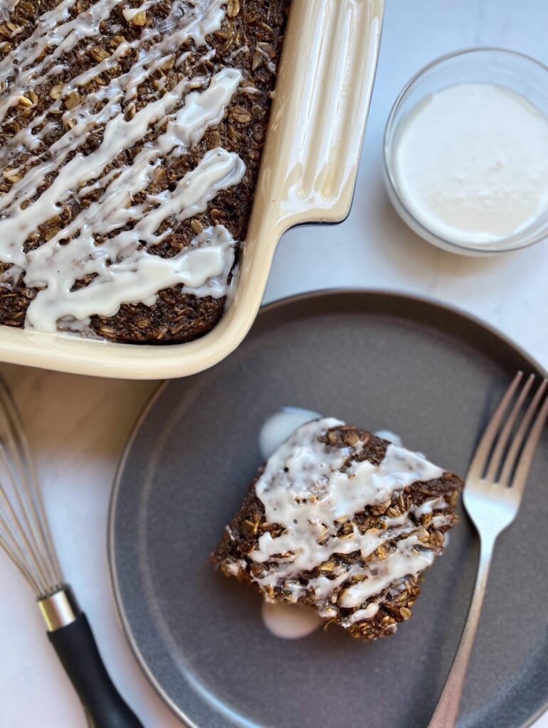 Overhead shot of a slice of Gingerbread Baked Oatmeal next to a pan of oatmeal