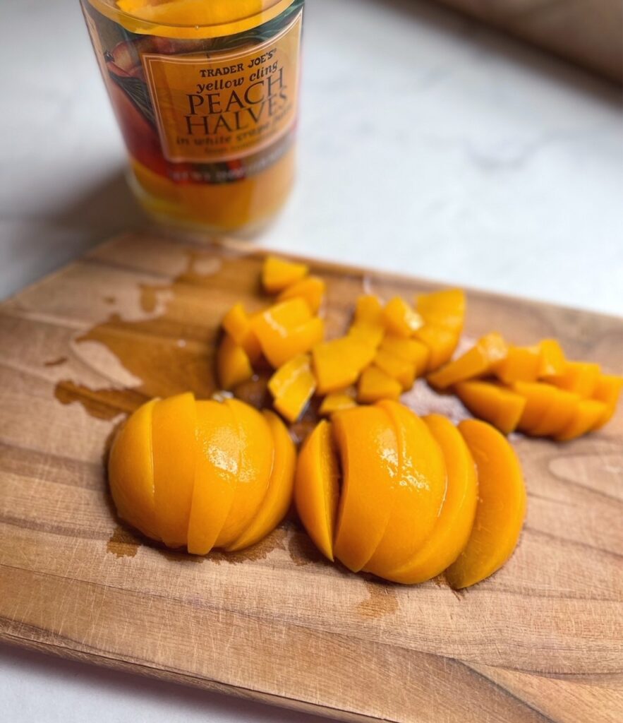 Close-up shot of sliced canned peaches on a cutting board