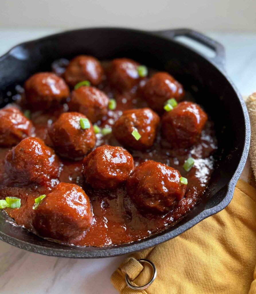 Side shot of Baked BBQ Beef Meatballs in a skillet